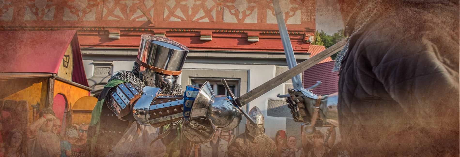 Ritter beim Kampf vor Fachwerkhaus